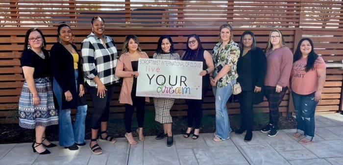 Live Your Dream award recipients in Clovis holding a 'live YOUR dream' sign